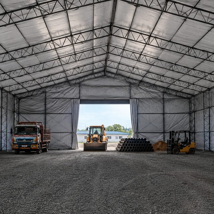 Exposed mild-steel truss roof spanning a wide column-free shed